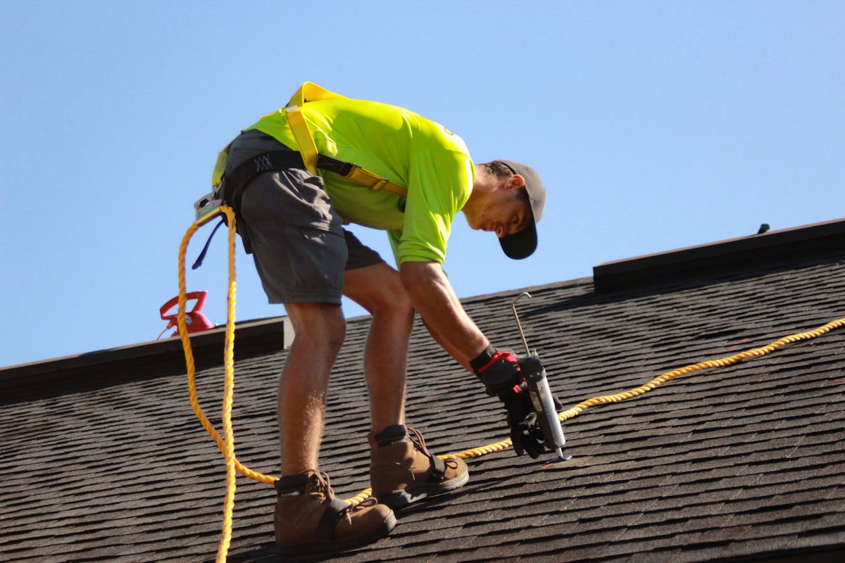 Roofer fixing ridge tiles with power drill